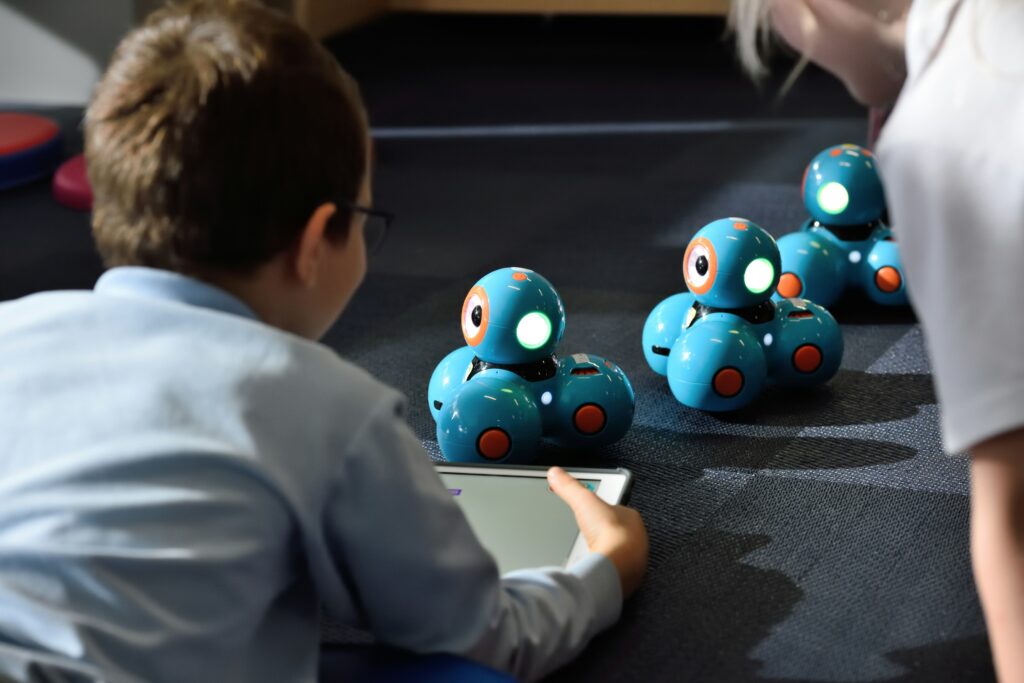 Student using an iPad to gather data concerning stacked piles of blue and red balls. 